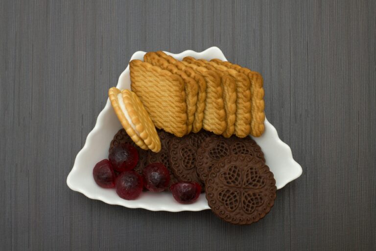 Close-up of various biscuits with colorful gumdrops on a decorative plate.